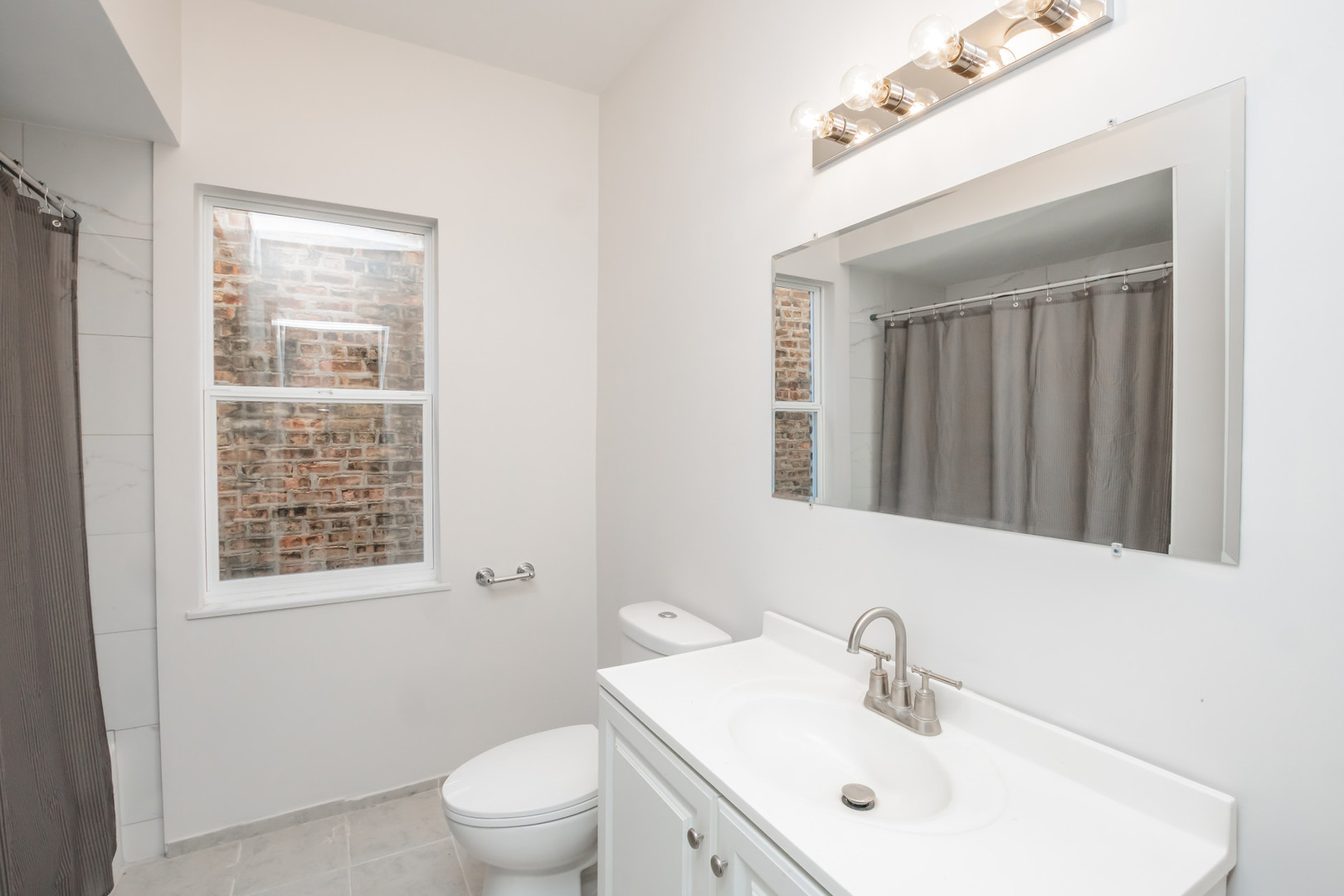 2136 North Avers Avenue, Unit 2 Chicago, IL 60647 - Photo 13 of 21 a bathroom with a sink a toilet and a mirror