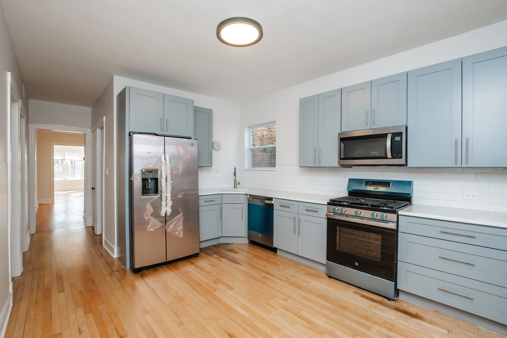 2136 North Avers Avenue, Unit 2 Chicago, IL 60647 - Photo 9 of 21 a kitchen with granite countertop a refrigerator and a stove top oven