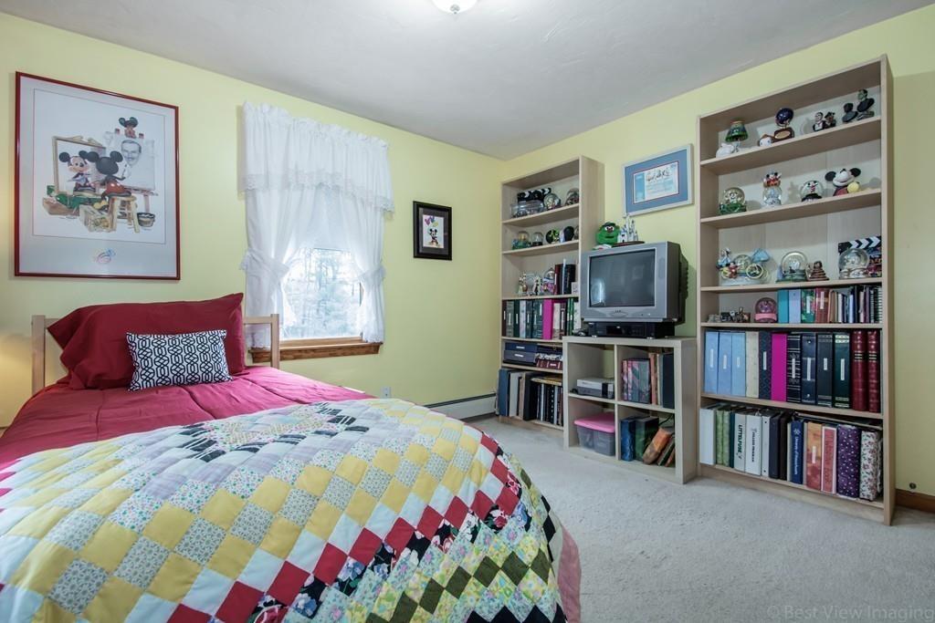 275 Reservoir Road Lunenburg, MA 01462 - Photo 19 of 31 a bedroom with a bed and book shelf