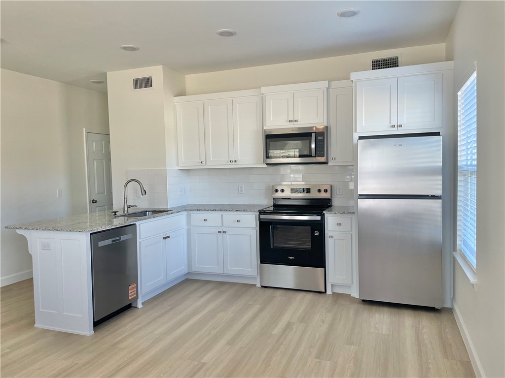 508 Park Street, Unit A Springdale, AR 72764 - Photo 4 of 7 Modern kitchen featuring white cabinetry, granite-style countertops, and a white subway tile backsplash