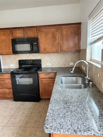 a kitchen with stainless steel appliances granite countertop a stove and a sink