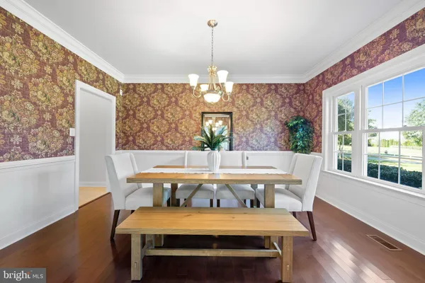 a kitchen with stainless steel appliances granite countertop wooden cabinets a dining table and chairs