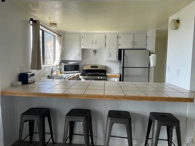 a kitchen with white cabinets and white appliances
