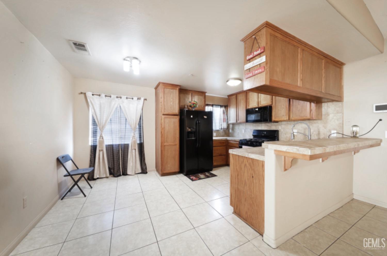 Undisclosed Address Bakersfield, CA 93306 - Photo 14 of 21 a kitchen with kitchen island granite countertop a refrigerator and a stove top oven
