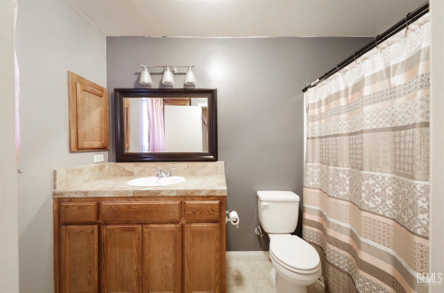 Undisclosed Address Bakersfield, CA 93306 - Photo 18 of 21 a bathroom with a toilet sink and mirror