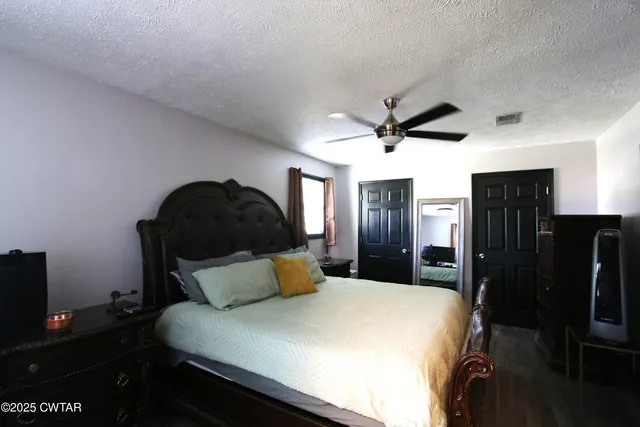 a bedroom with a bed and a ceiling fan