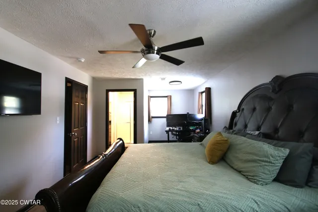 a bed room with a bed window and a television