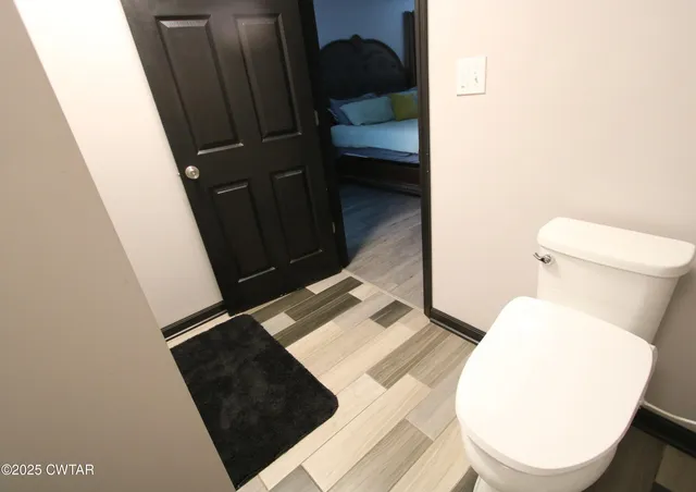 a bathroom with a toilet and a mirror