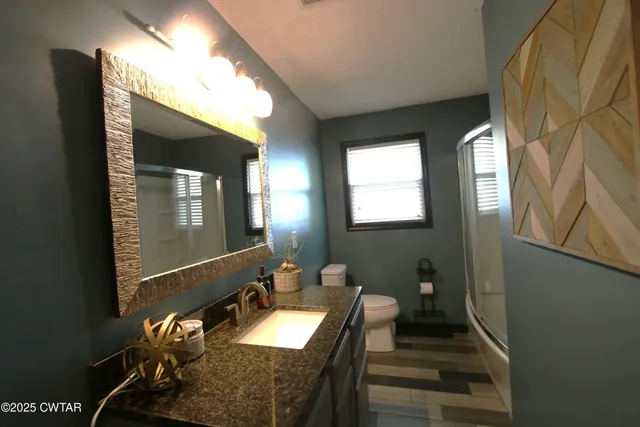 a bathroom with double vanity and a mirror
