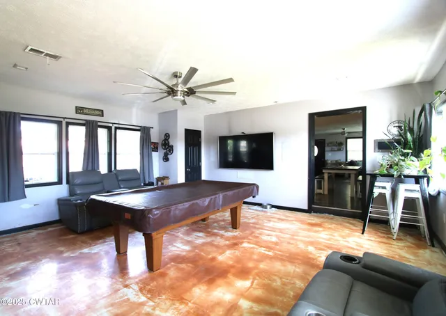 a living room with furniture a flat screen tv and a table