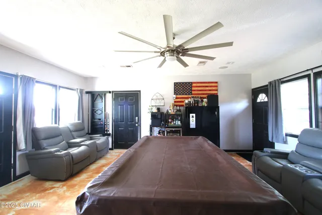 a living room with furniture and a ceiling fan
