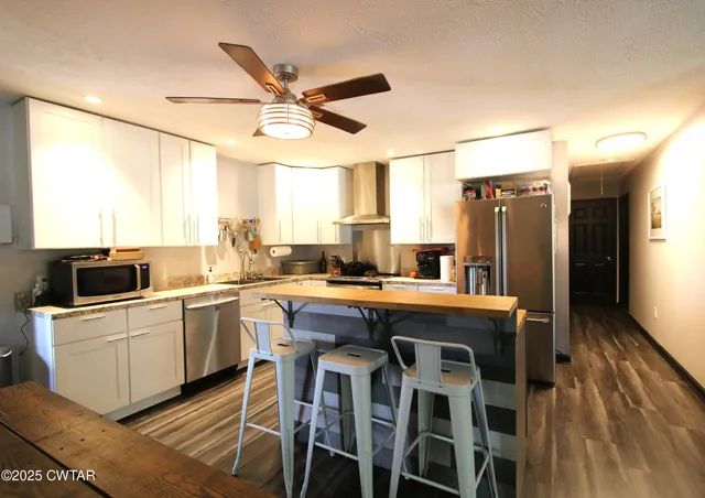 a kitchen with a table chairs refrigerator and microwave