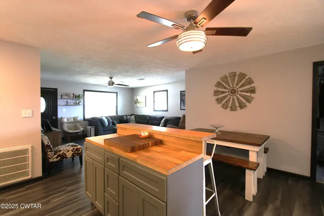 a room with chandelier fan and wooden floor