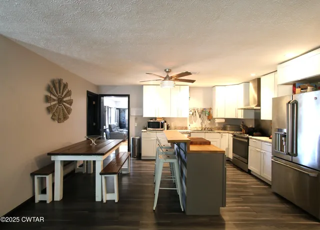 a kitchen with a table chairs refrigerator and cabinets