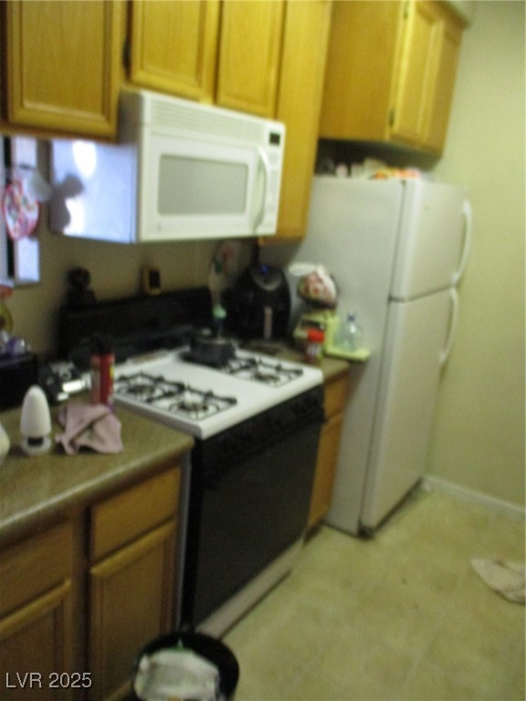 3318 North Decatur Boulevard, Unit 1044 Las Vegas, NV 89130 - Photo 7 of 18 Kitchen with fridge, stove, and brown cabinets