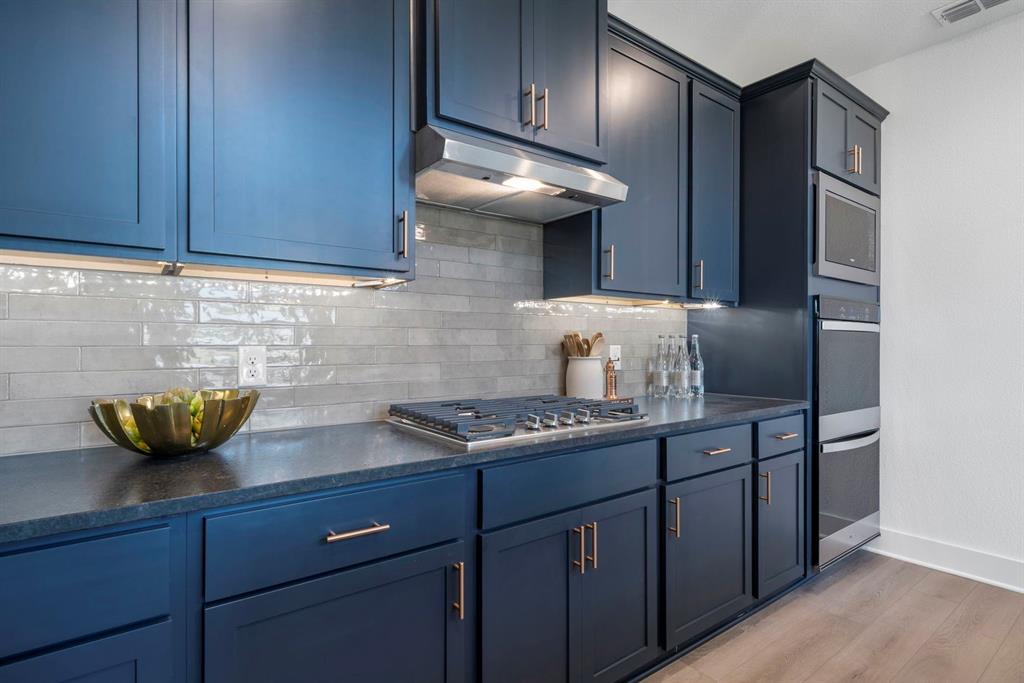 9301 Shadow Trail Little Elm, TX 75068 - Photo 3 of 10 a kitchen with stainless steel appliances granite countertop wooden cabinets and a sink