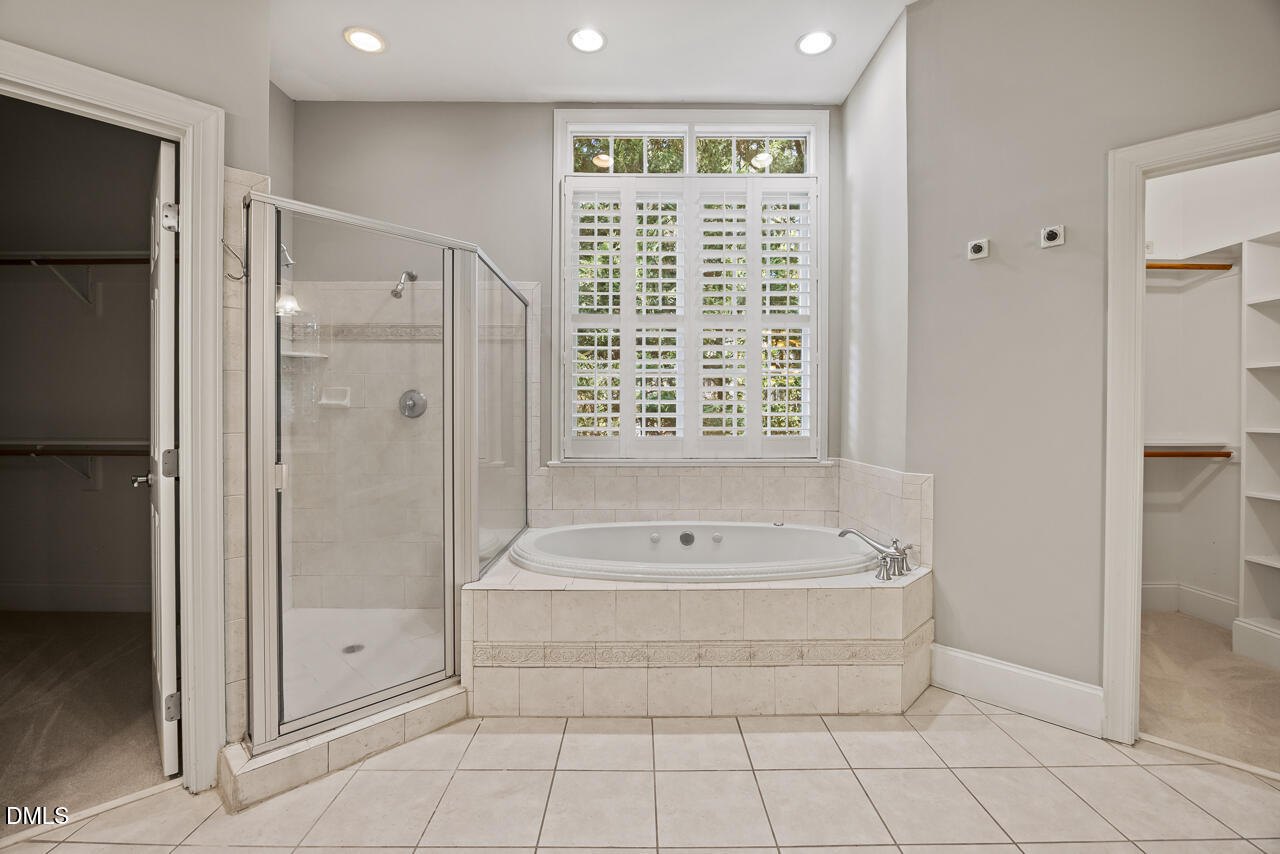 4004 Frontenac Court Apex, NC 27539 - Photo 30 of 61 a bathroom with a tub a sink and a shower