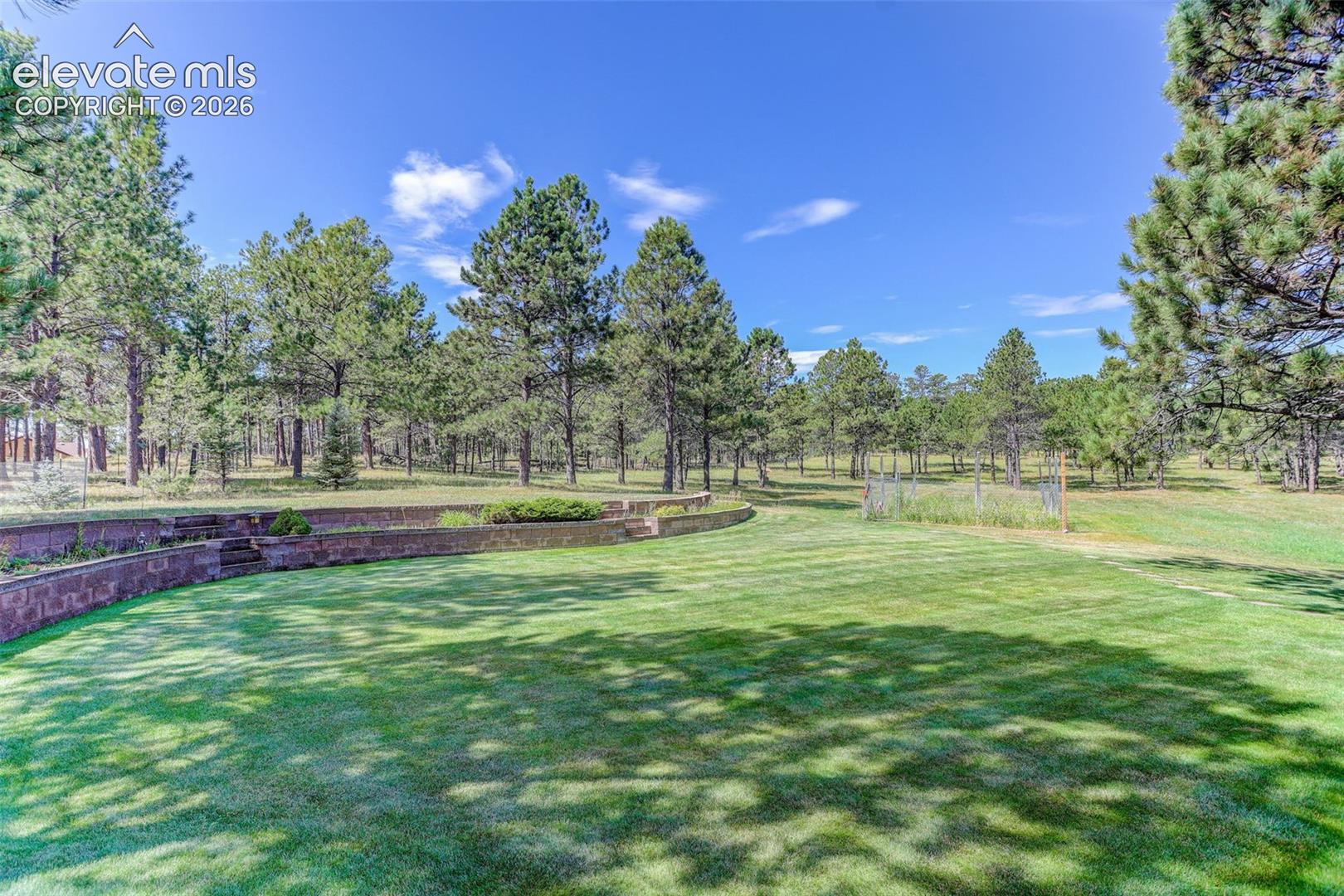 Landscaped back yard with deer-proof fenced garden plot. 