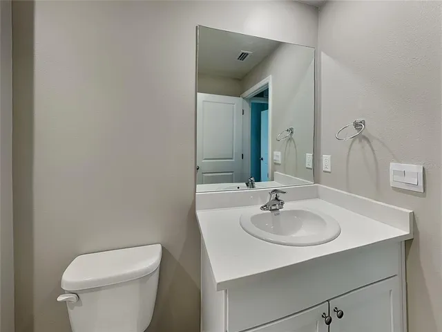 a bathroom with a sink a toilet and a mirror