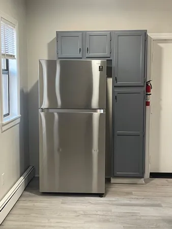 a view of a refrigerator in kitchen and wooden floor