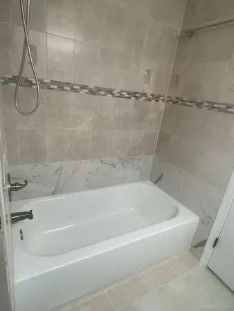 a white bath tub sitting next to a white sink and vanity