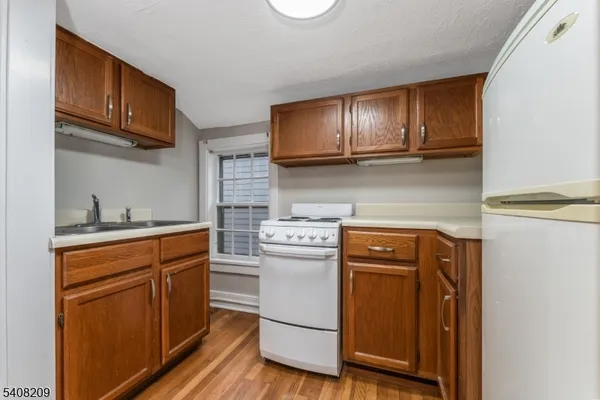 a kitchen with stainless steel appliances granite countertop wooden cabinets a stove top oven a sink and dishwasher