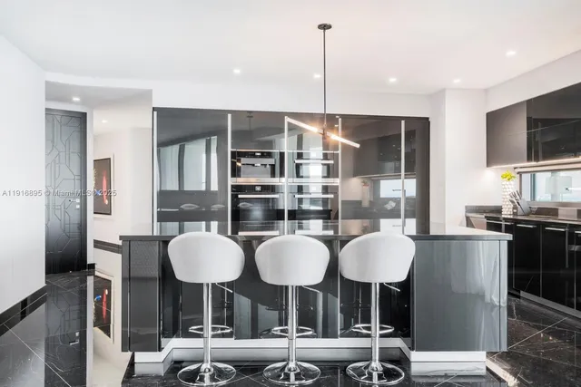 a kitchen with stainless steel appliances granite countertop a table and chairs