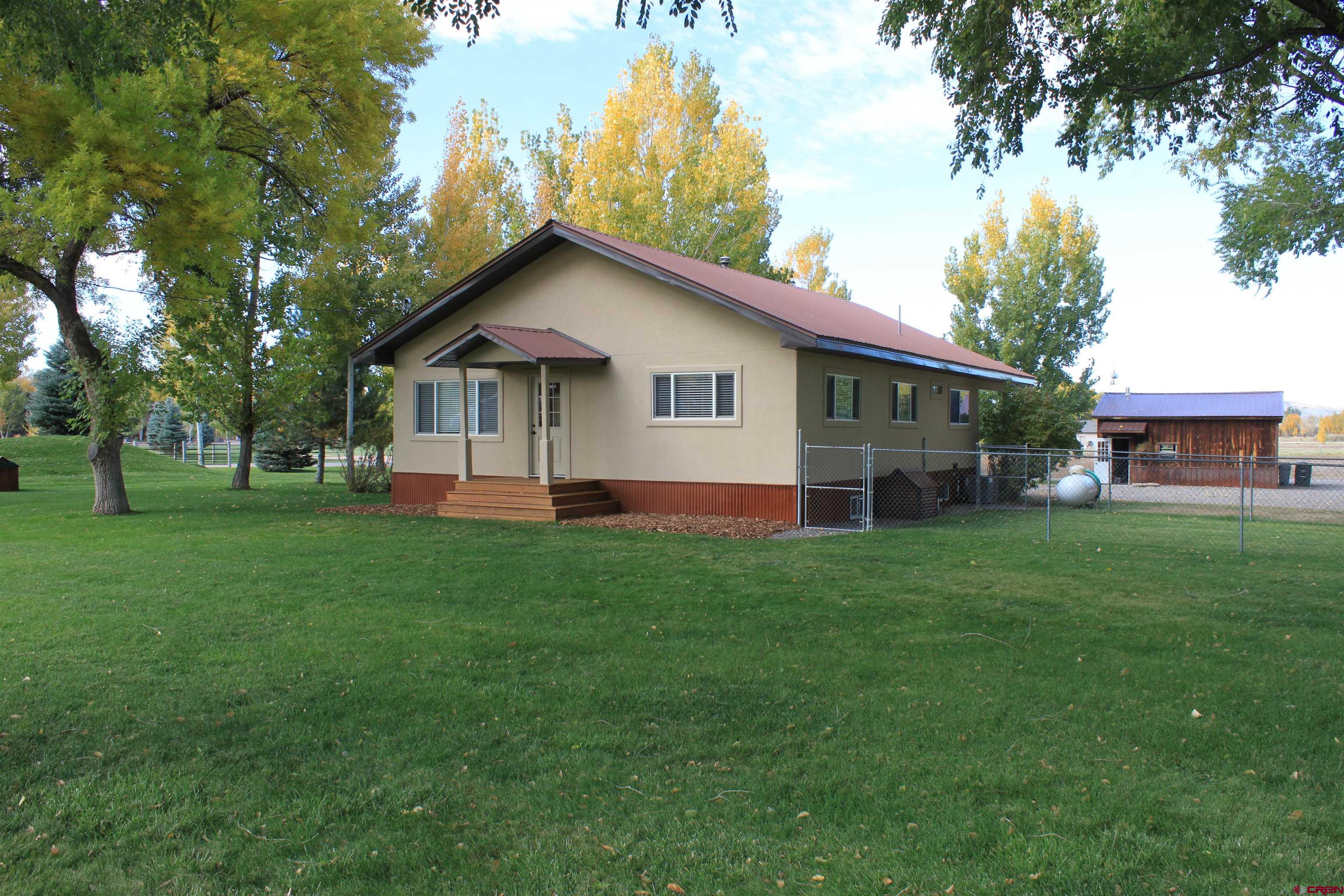 20976 6840th Road Montrose, CO 81403 - Photo 1 of 33 a view of a house with a yard and tree s