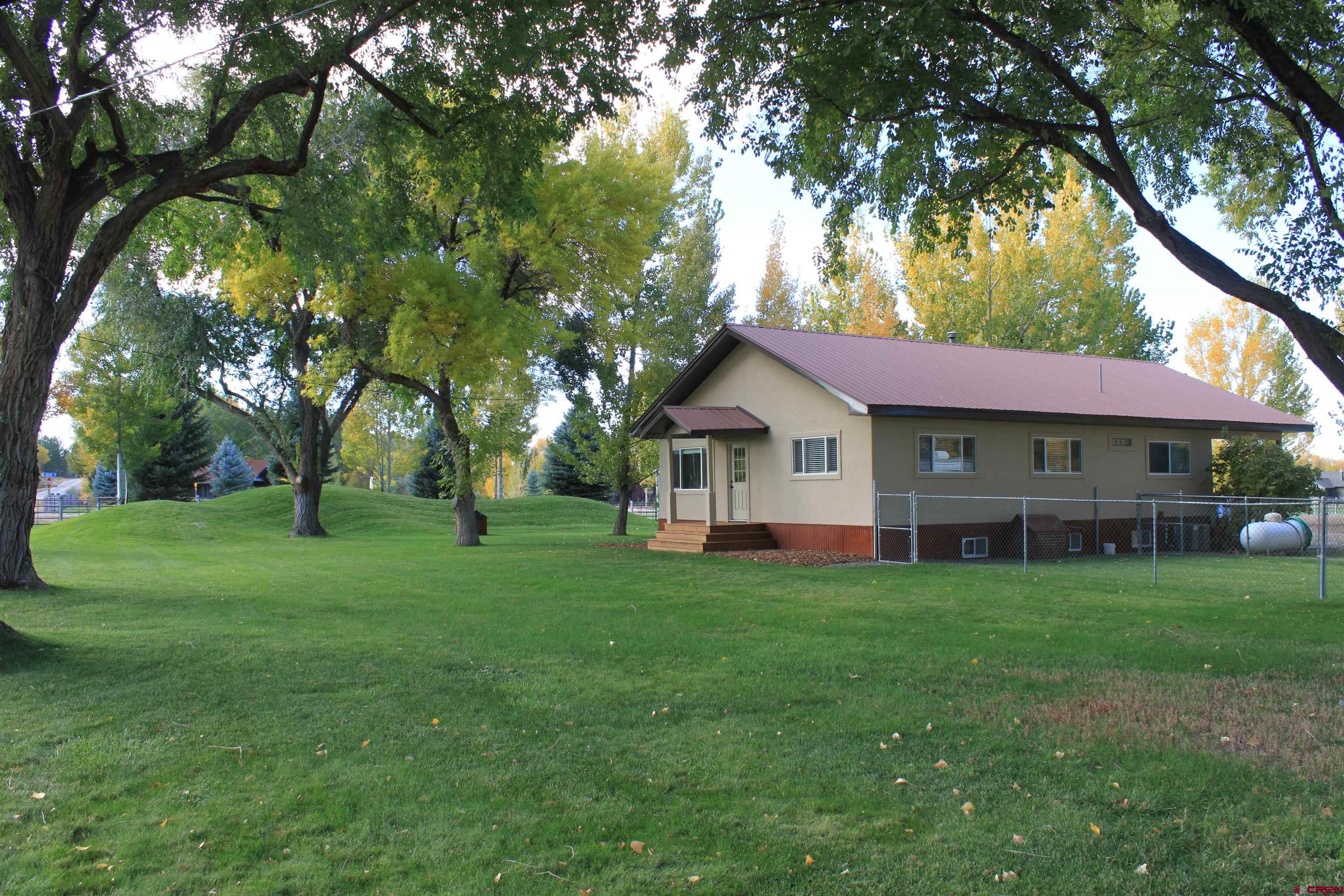 20976 6840th Road Montrose, CO 81403 - Photo 2 of 33 a view of a house with a big yard and large trees