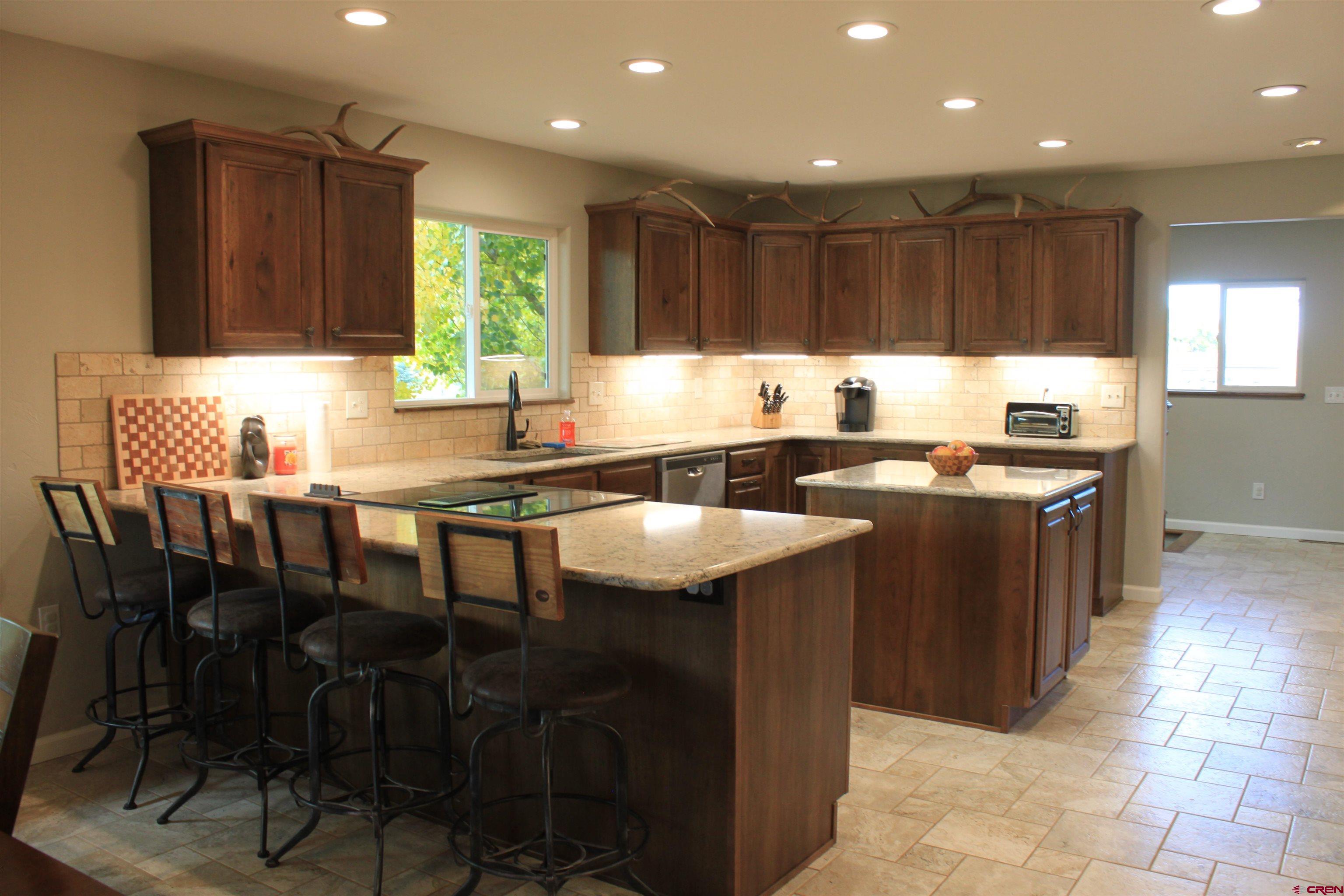 20976 6840th Road Montrose, CO 81403 - Photo 8 of 33 a kitchen with stainless steel appliances granite countertop a table chairs sink and cabinets