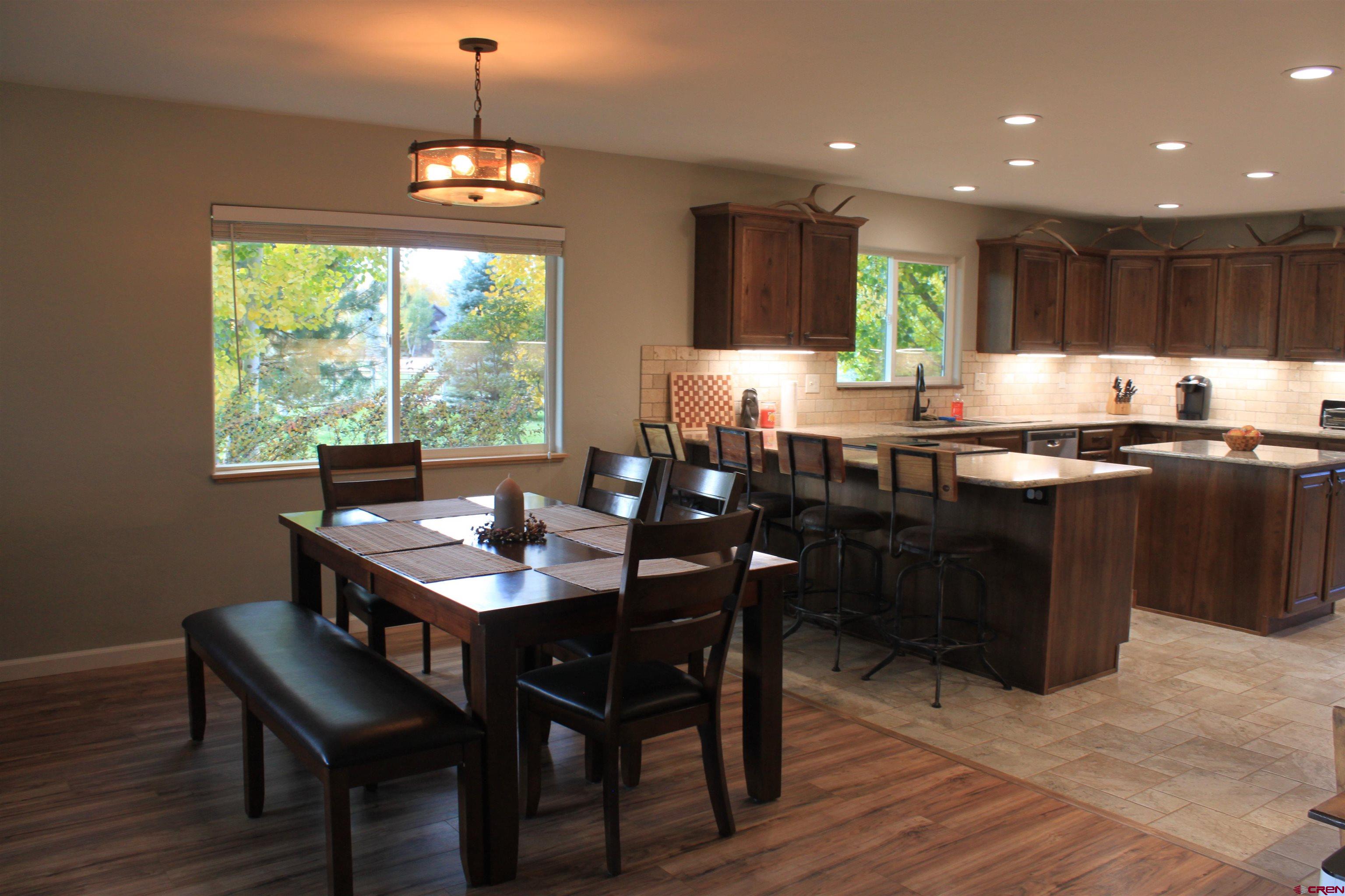 20976 6840th Road Montrose, CO 81403 - Photo 9 of 33 a kitchen with granite countertop a sink table and chairs