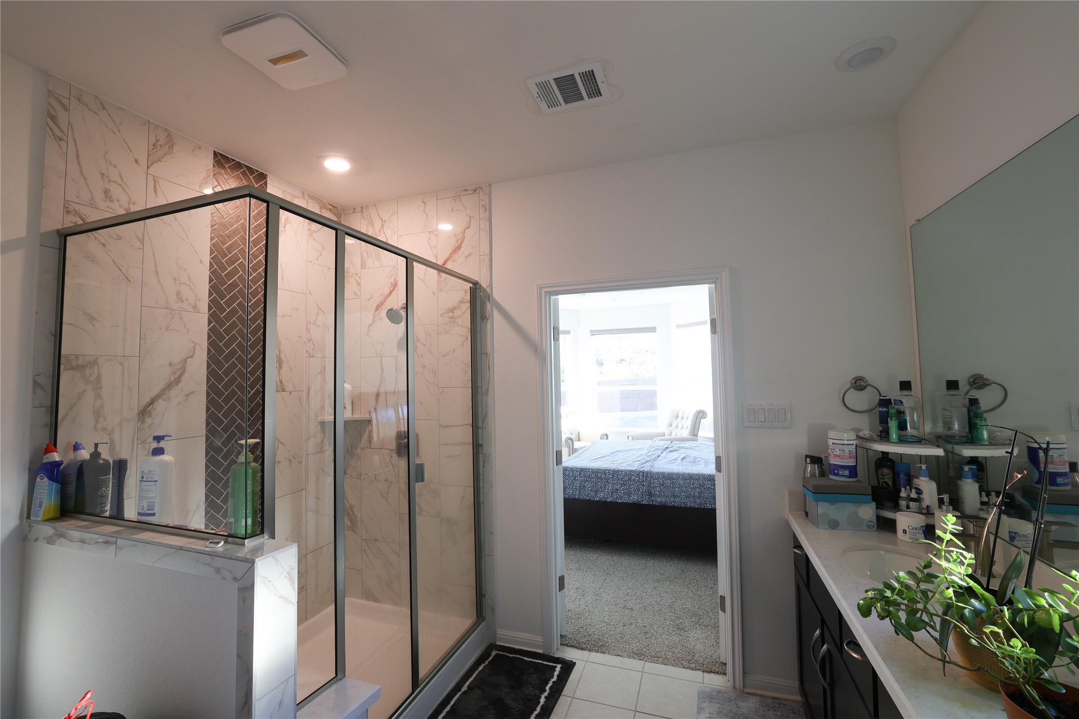232 Barton Oak Trail Georgetown, TX 78628 - Photo 17 of 19 Bathroom with vanity, a marble finish shower, connected bathroom, light carpet, and light tile patterned floors