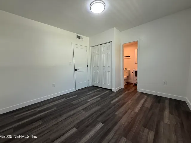 a view of a room with wooden floor and a sink