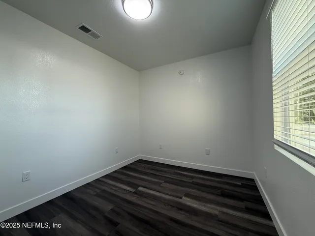 a room with wooden floor and a window