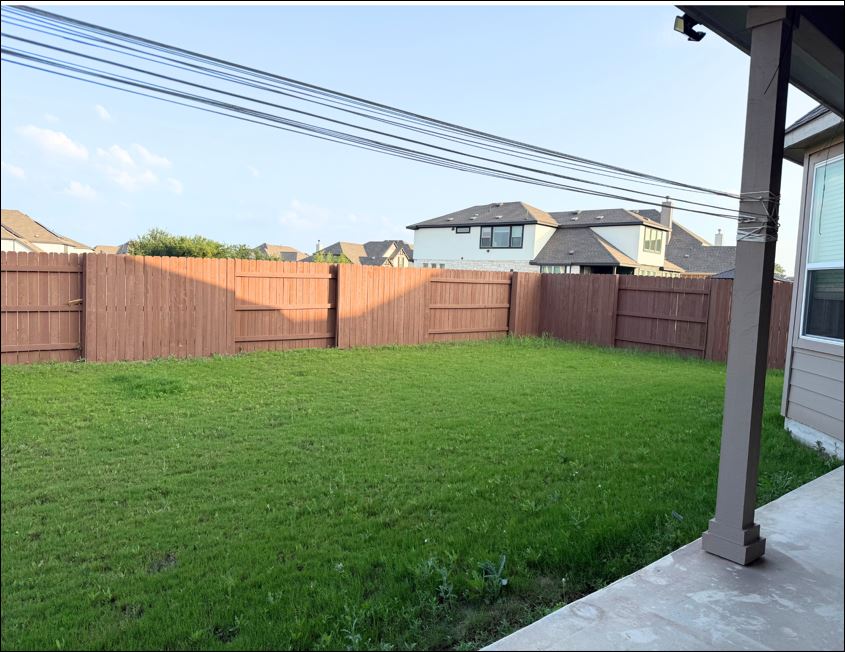 109 Rocky River Road Georgetown, TX 78628 - Photo 5 of 10 A fully fenced backyard with a green lawn awaits outdoor enjoyment.