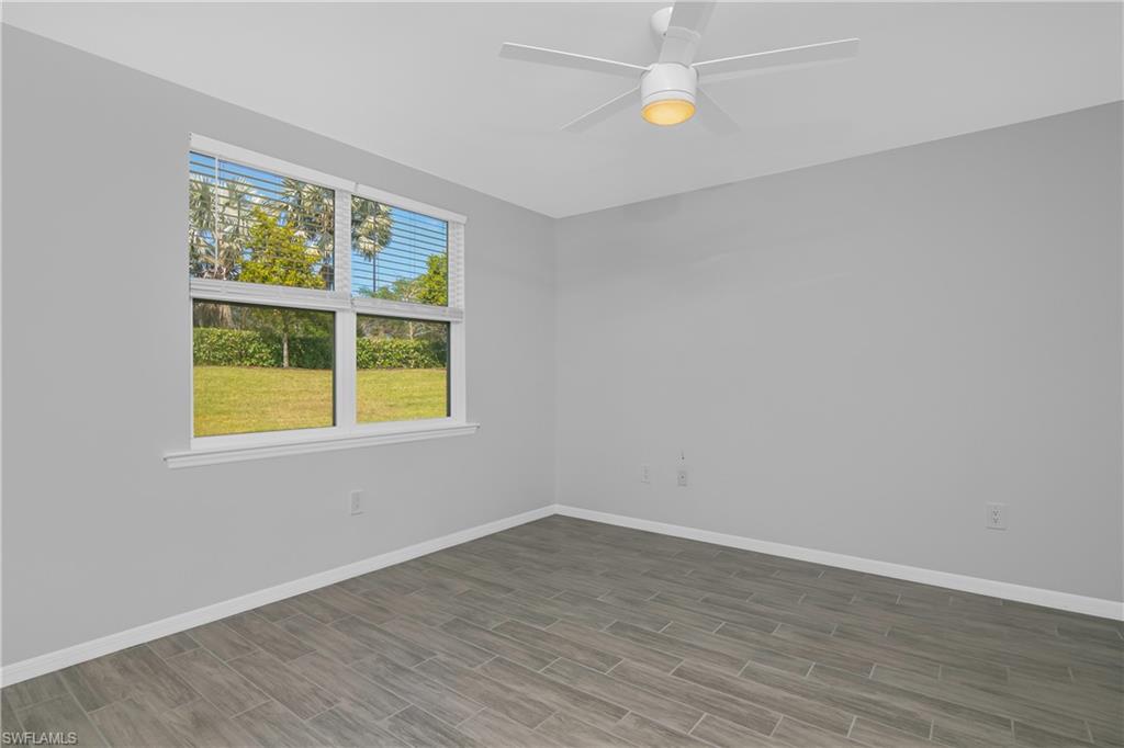 14559 Edgewater Circle Naples, FL 34114 - Photo 12 of 49 wooden floor in an empty room with a window