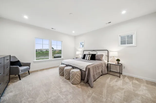 a spacious bedroom with a bed and glass window
