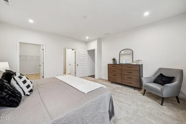 a spacious bedroom with a bed a couch and dresser