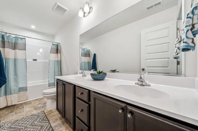 a bathroom with a double vanity sink toilet and shower