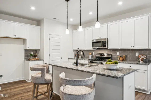a kitchen with a sink a stove a microwave and cabinets