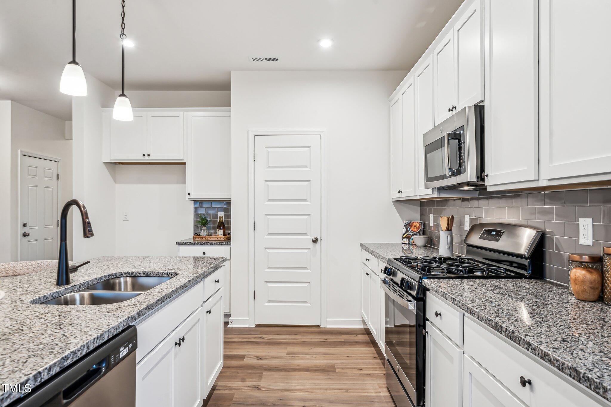 149 Cribbs Lane Middlesex, NC 27557 - Photo 7 of 33 a kitchen with stainless steel appliances granite countertop a sink stove and cabinets
