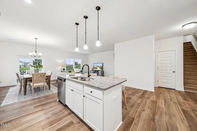a kitchen with a sink and wooden floor