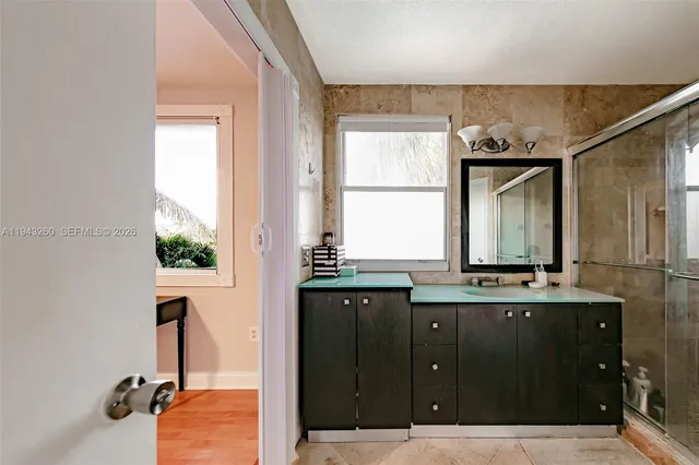 a bathroom with a sink mirror and window