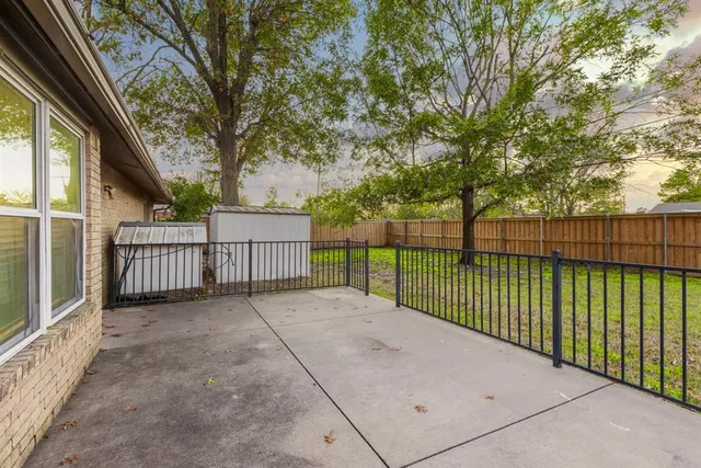 a view of a fence and trees in the background