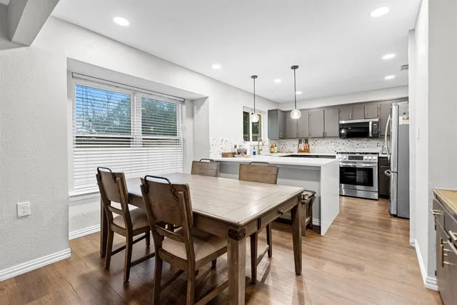 a kitchen with kitchen island a dining table and chairs
