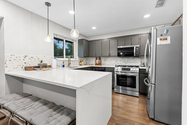 a kitchen with kitchen island a stove a sink and a refrigerator