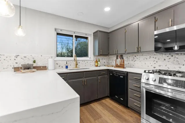 a kitchen with a sink stove top oven and cabinets