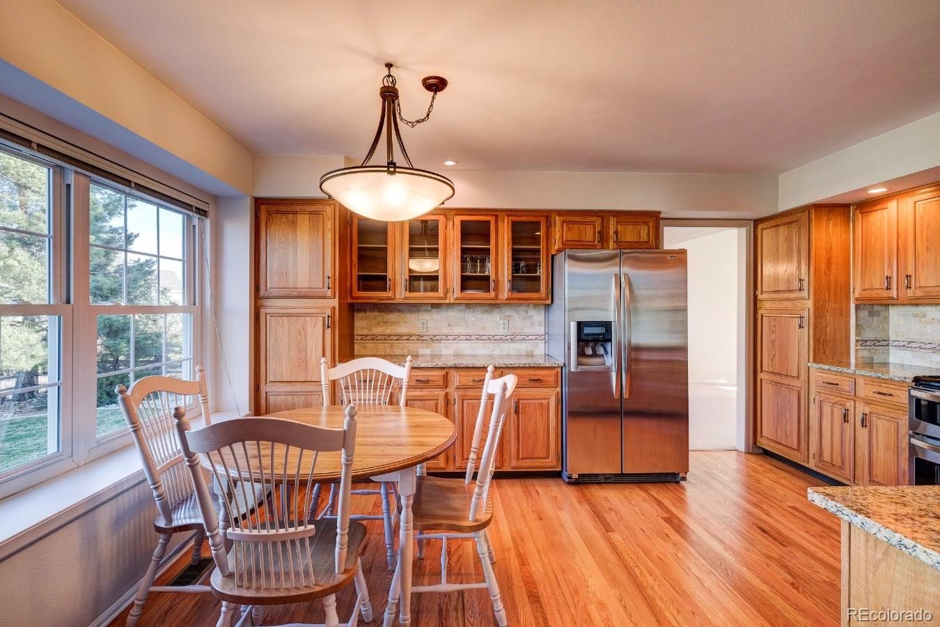 8927 Mountain Laurel Way Highlands Ranch, CO 80126 - Photo 11 of 35 a dining room with furniture a chandelier and wooden floor