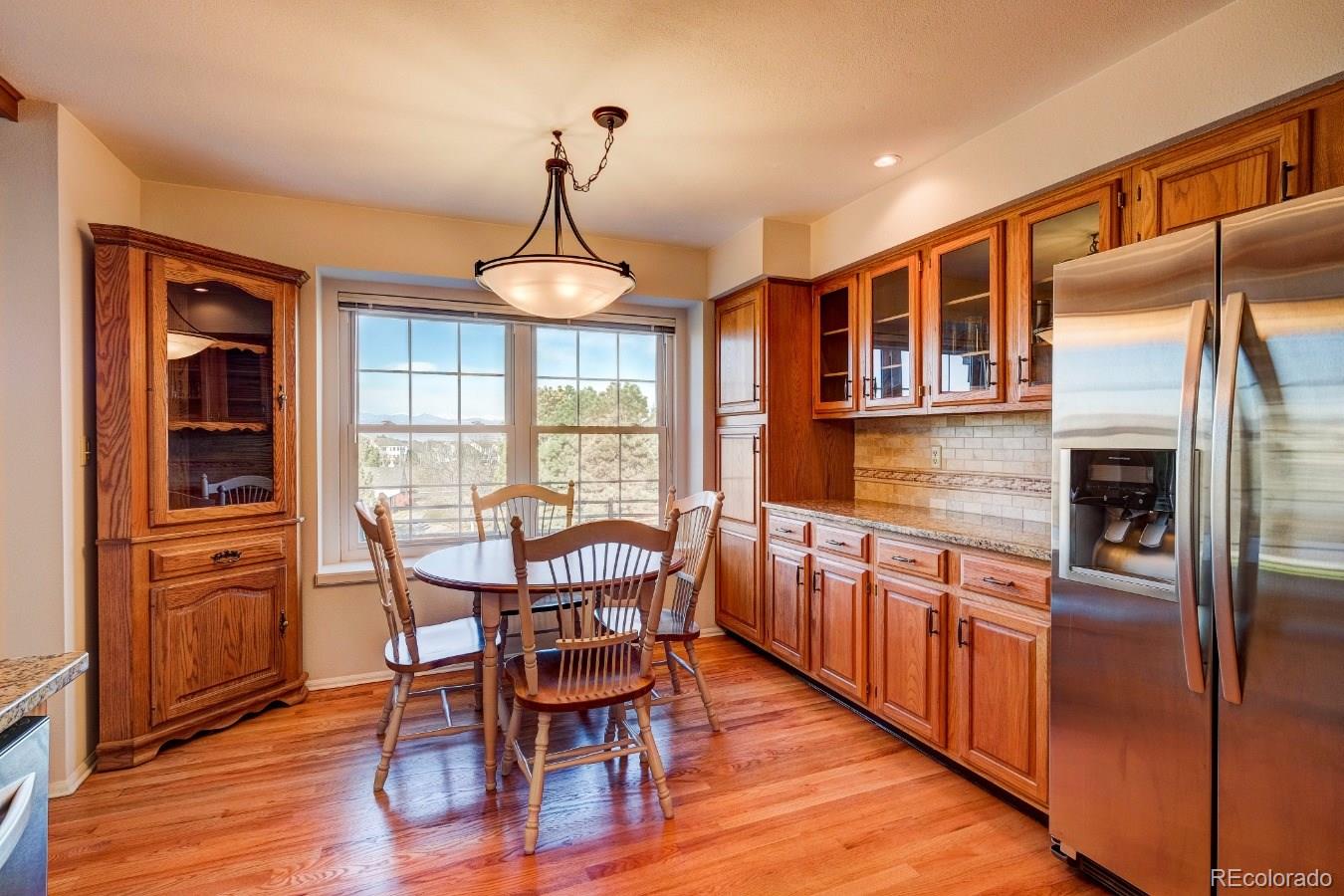8927 Mountain Laurel Way Highlands Ranch, CO 80126 - Photo 13 of 35 a view of a dining room with furniture window and wooden floor