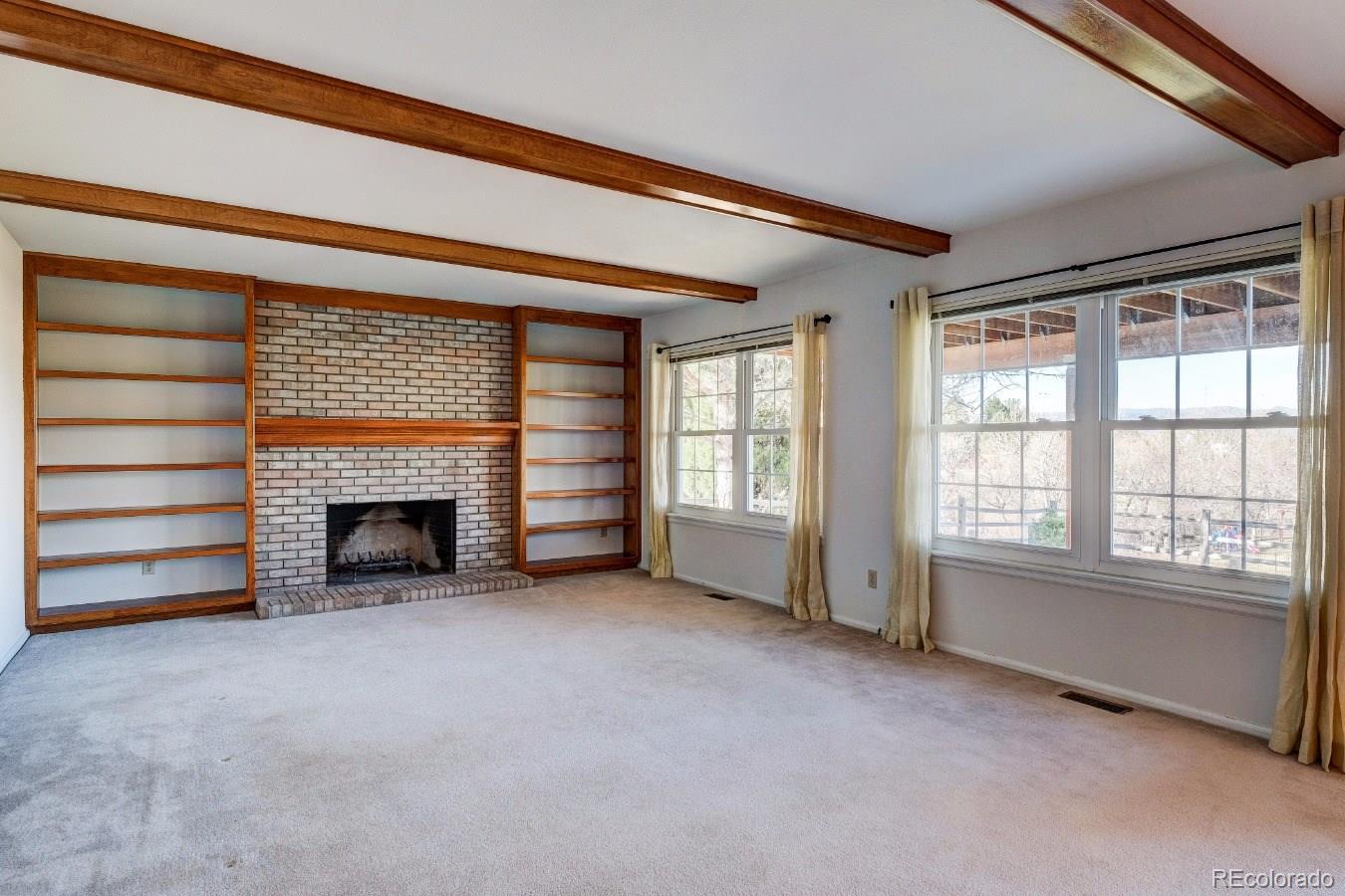 8927 Mountain Laurel Way Highlands Ranch, CO 80126 - Photo 15 of 35 an empty room with furniture and a fireplace